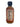 A clear glass 2 oz bottle of Smokin' Ed's Chipotle Express hot sauce with an orange liquid, black cap, and a label showing nutrition facts, ingredients, a flame design, serving size, calories, and nutritional info.