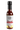 Smokin' Ed's Special Reserve comes in a glass bottle with a black cap and a gold and white label featuring flames and five chili peppers, highlighting its blend of the world’s hottest peppers, including Carolina Reaper.