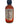 A 2 oz glass mini bottle of Puckerbutt's Reaper Squeezins hot sauce with a black cap. The label features nutrition info, ingredients, and red flames, hinting at the intense heat of the vibrant orange-red sauce inside.