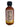A 2 oz mini bottle of Smokin' Ed's Honey Half Note hot sauce displays the back label with nutrition facts, peppers, vinegar, spicy honey, cinnamon ingredients, and a musical note design in the background.