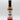 A bottle of Smokin' Ed's Hoisin - Mild with a black cap and white label featuring red flames, a logo, and bold lettering—a great choice for those who enjoy a flavorful but milder hoisin chili pepper sauce.