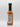 A bottle of Smokin' Ed's Korean Dumpling - Mild chili sauce with a black cap is shown upright on a plain white background. The back label, though mostly unreadable, lists nutrition facts and ingredients. Great for zesty Korean dumplings.