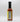 A bottle of Smokin' Ed's Pineapple Teriyaki - Medium hot sauce with a black cap sits against a white background. The back label displays nutrition facts and ingredients, while the vibrant red-orange sauce highlights bold chile peppers.