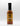 A bottle of Smokin' Ed's Sazon - Pepper X with a black cap, orange label, and flame graphics at the bottom stands upright against a plain white background.