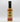 A bottle of Smokin' Ed's Shawarma - Mild sauce with a black cap and a cream-colored label featuring red flames, text, and logo at the top. Infused with garlic and chili powder, it stands on a white surface against a plain background.