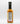 A bottle of Smokin' Ed's Shawarma - Mild with a black cap displays its nutrition facts and ingredients label. The orange sauce inside features bold red flame graphics and highlights garlic and chili powder on the side of the label.