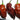 Three wrinkled, reddish-brown Chocolate Bhutlah chili peppers with green stems are shown against a white background. These superhot, irregularly shaped pods highlight the unique texture you can grow from Chocolate Bhutlah seeds.