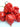 A cluster of bright red, wrinkled Moruga chili peppers with green stems, known for their extreme heat and bold tropical flavor, displayed against a plain white background.
