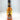 A bottle of Mikey V's Garlic Scorpion, with bold scorpion and garlic art on its orange label, showcases intense Scorpion Pepper and tomato puree flavors—all set against a plain white background.