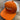 The Orange/White PuckerButt Snapback Hat features the embroidered PuckerButt Pepper Company logo with a red and green chili and "PURE. ORGANIC." text, displayed on a wooden surface.