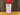 White Wolf Rubs Red Wolf Cajun Seasoning, with a red lid, sits on wood in front of a tree trunk. The label suggests using this spicy rub for gumbo or grilling.